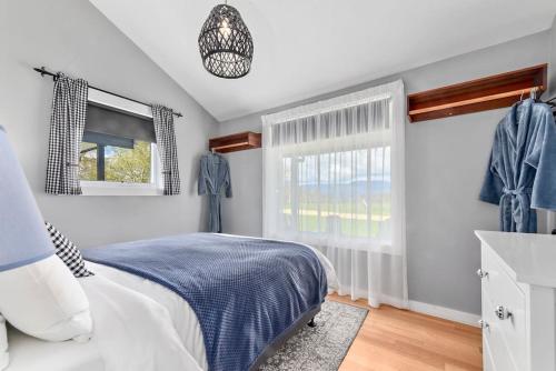 Un dormitorio con una cama azul y blanca y una ventana en Wakefields - an enchanting mountain view cottage, en Mole Creek