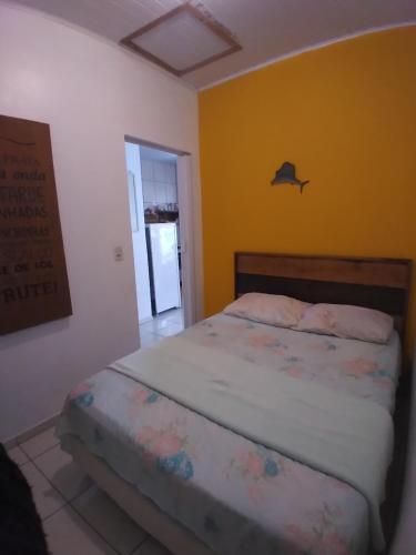 a bedroom with a bed and a yellow wall at Casa verde in Laguna