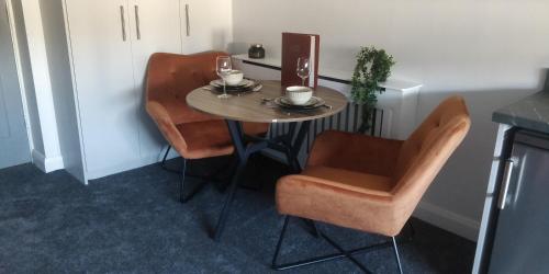 een kleine tafel met twee stoelen en een tafel met wijnglazen bij Free Derry Apartments in Derry Londonderry