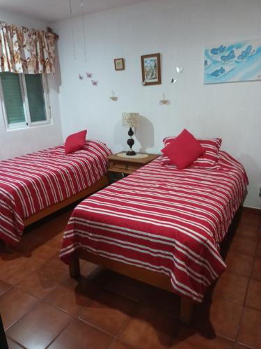 2 camas en una habitación con mantas rojas y blancas en Mariposas Rooms, en Cancún
