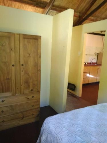 - une chambre avec un lit et des placards en bois dans l'établissement Cabaña Malbec, à Luján de Cuyo