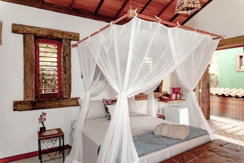 a bedroom with a bed with a canopy at Canto dos Sonhos Caraíva in Caraíva