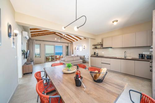 a kitchen and living room with a table and chairs at Villa Katoikia Dio by Villa Plus in Simotáta
