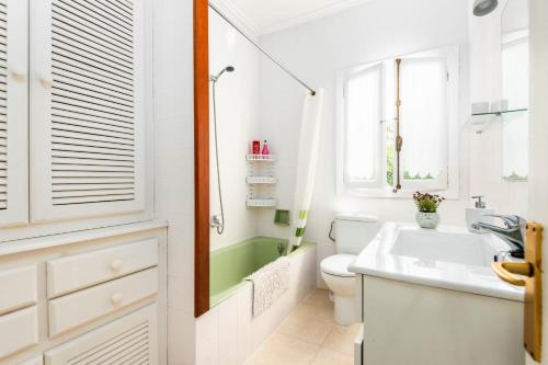 uma casa de banho branca com um lavatório e um WC em Villa Can Sintes by Villa Plus em Es Mercadal