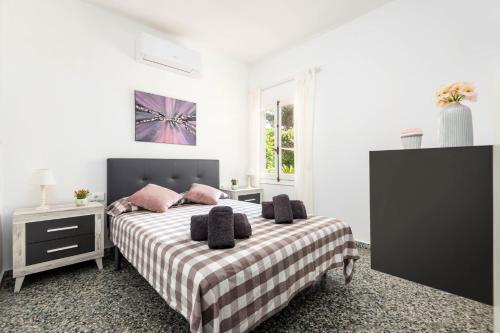 um quarto branco com uma cama com almofadas cor-de-rosa em Villa Can Sintes by Villa Plus em Es Mercadal