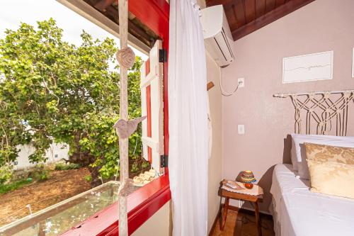 a room with a bed and a window with a view at CasinhaPiri in Pirenópolis
