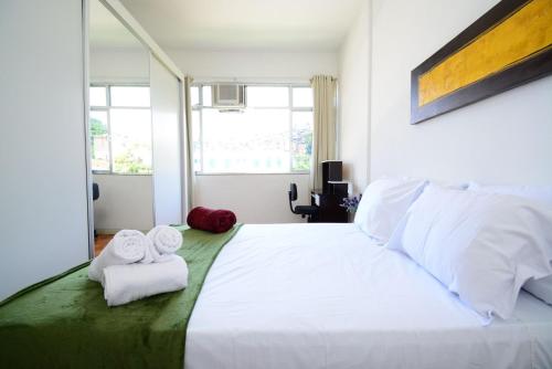 1 dormitorio con 1 cama blanca grande y toallas. en Rio Histórico - Glória, Conforto e Praticidade, en Río de Janeiro