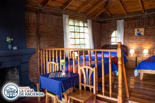 a bedroom with a bed and a table and chairs at La Casa de Hacienda in Otavalo