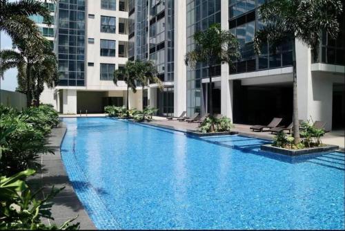 a swimming pool in the middle of a building with palm trees at Eastwood High Life - Spectacular City View in Manila