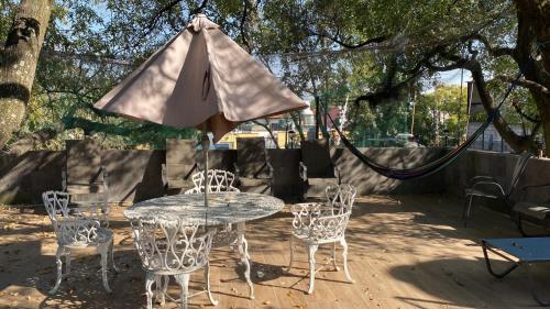 een tafel en stoelen met een parasol op een patio bij frida in Mexico-Stad