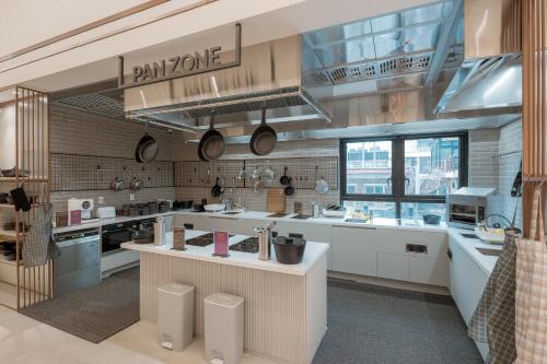 a large kitchen with white counters and appliances at Chestertons Sokcho in Sokcho