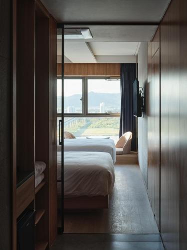 a hotel room with two beds and a window at Hotel tt Gupo in Busan