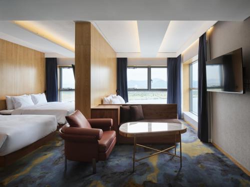 a hotel room with two beds and a couch and a tv at Hotel tt Gupo in Busan