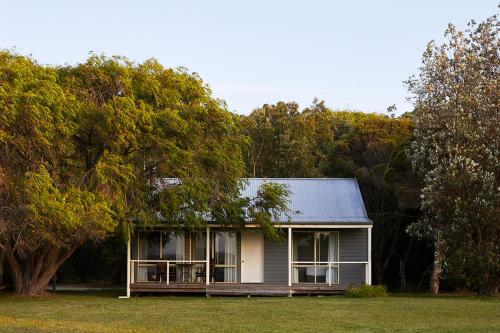 a small house sitting in the middle of a field at Mystery Bay Cottages in Mystery Bay