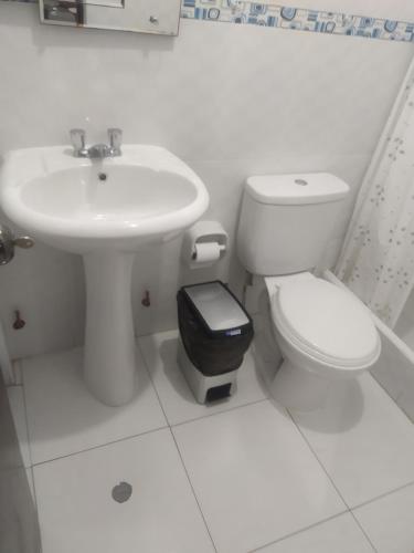 Baño blanco con lavabo y aseo en Ambigua Hospedaje, en Trujillo