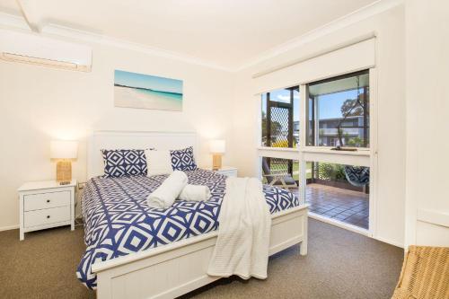 1 dormitorio con cama y ventana grande en Hayes Beach House I Award Winner I 4 Mins to Beach en Callala Beach