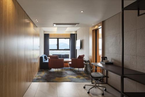 a room with a desk and chairs and a table at Hotel tt Gupo in Busan