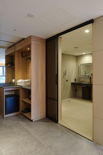 a room with a sliding glass door leading to a bathroom at Hotel tt Gupo in Busan