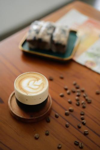 a cup of coffee and a plate of donuts on a table at CERIA HOTEL at Alun Alun Yogyakarta in Yogyakarta
