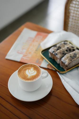 a cup of coffee and a plate of food on a table at CERIA HOTEL at Alun Alun Yogyakarta in Yogyakarta
