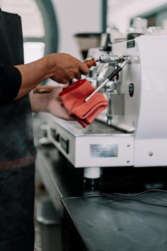 a person using a sewing machine in a kitchen at CERIA HOTEL at Alun Alun Yogyakarta in Yogyakarta