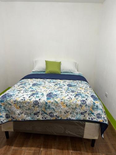 a bedroom with a bed with a blue and white quilt at Casa Díaz in Quetzaltenango