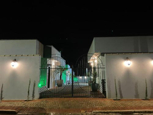 a gate to a house at night with lights at Pousada Família Bueno in Monte Alegre do Sul