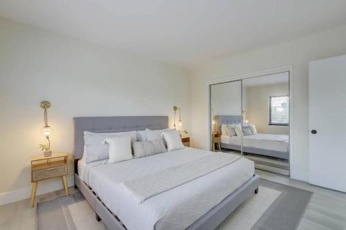 a white bedroom with a large bed and a mirror at Beachy&Boho apt for 6 people with kitchen and pool in Fort Lauderdale