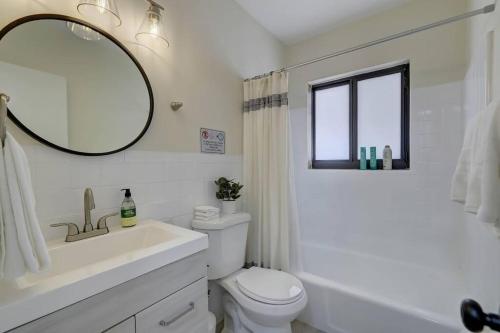 a bathroom with a sink and a toilet and a mirror at Beachy&Boho apt for 6 people with kitchen and pool in Fort Lauderdale