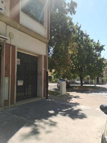 a building with a garage with a tree next to it at Casa Trezza 2 in Latina