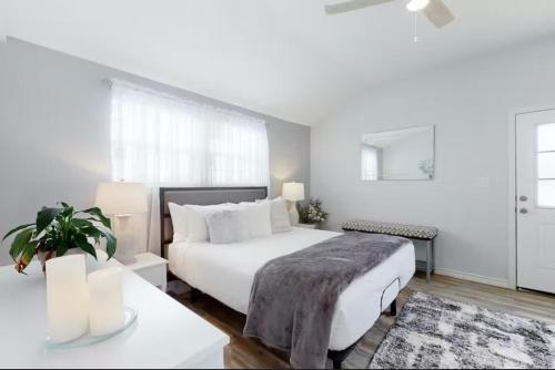 a white bedroom with a large bed and a table at Blue Oasis in the Hill Country in Kerrville