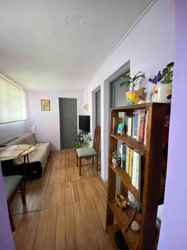 uma sala de estar com uma estante de livros e um sofá em Humilde espacio en el corazón de Minas em Minas