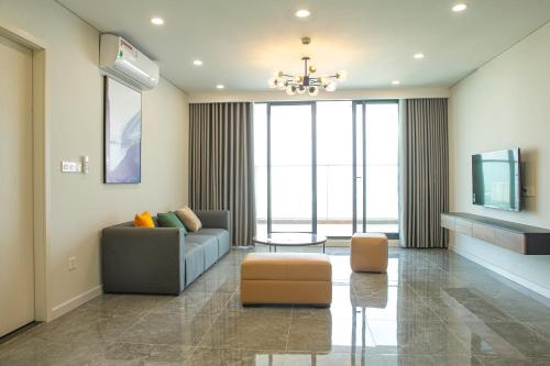 a living room with a couch and a tv at TSQ STAY Hotel Apartment in Hanoi