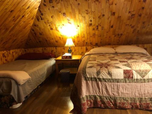 a bedroom with two beds and a lamp on a table at 78 Montague in Digby