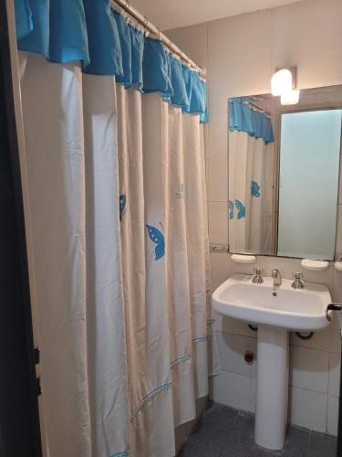 a bathroom with a sink and a shower curtain at Departamento Calle Corrientes in San Miguel de Tucumán