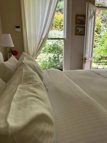 a white bed in a room with a window at Rowan Brae Historic Guesthouse in Blackheath