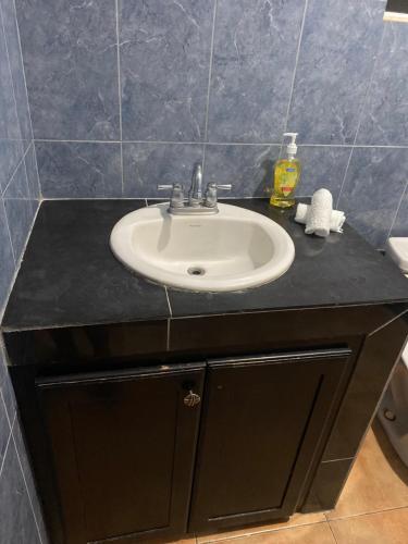 a bathroom sink with a black counter top at Marshan villa in Montego Bay