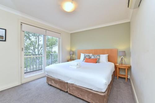 - une chambre avec un grand lit et une fenêtre dans l'établissement Villa 3br Bordeaux located within Cypress Lakes Resort, à Pokolbin