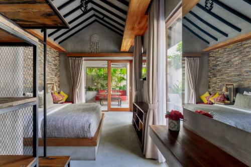 een slaapkamer met 2 bedden en een bakstenen muur bij Vinna Villa Seminyak by The Wina Resorts in Kerobokan