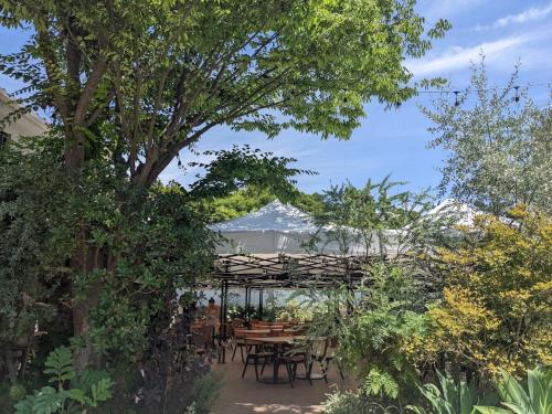 uma mesa e cadeiras sob uma pérgula num jardim em BIRD HOTEL em Kamakura