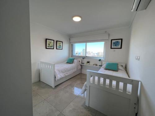 a bedroom with two beds and a window at Miami Boulevard II excelente, a 100 metros del mar in Punta del Este