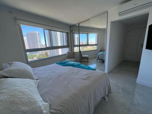 1 dormitorio con 1 cama grande y ventanas grandes en Miami Boulevard II excelente, a 100 metros del mar, en Punta del Este