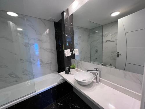 ein Badezimmer mit einem Waschbecken, einer Badewanne und einem Spiegel in der Unterkunft Miami Boulevard II excelente, a 100 metros del mar in Punta del Este