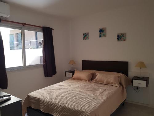 1 dormitorio con cama y ventana en Departamento Zona Centro 2 a 4 personas en Colón