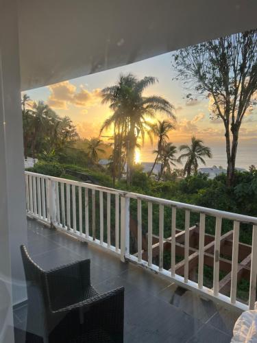 a balcony with a view of the ocean and palm trees at Amazing views!! in Santa Bárbara de Samaná