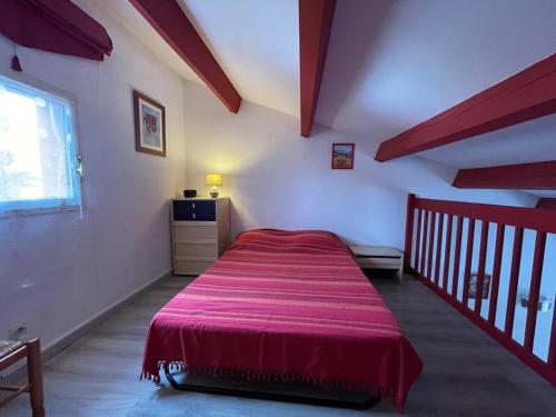 une chambre avec un lit rouge dans une pièce dans l'établissement Maison 2 pièces/mezzanine climatisée, 6 couchages, proche mer avec terrasse et parking privé - FR-1-225D-161, à Saint-Cyprien