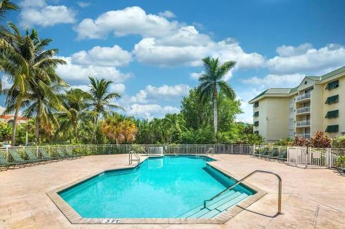 einen Pool in einem Resort mit Palmen in der Unterkunft Comfy 2/2 condo with pool/gym/tennis/hot-tub in Key West