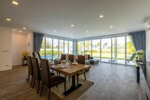 a dining room with a wooden table and chairs at Modern 3 bedroom Pool Villa PG19 in Cha Am