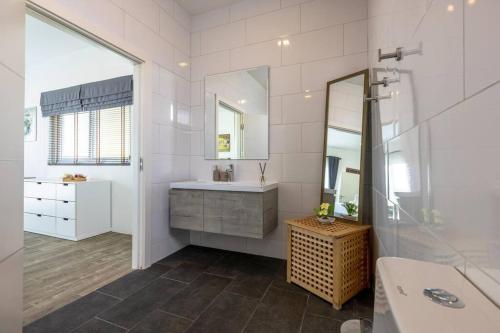 une salle de bain blanche avec un lavabo et un miroir dans l'établissement Modern 3 bedroom Pool Villa PG19, à Cha Am