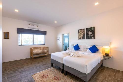 - une chambre avec 2 lits dotés d'oreillers bleus dans l'établissement Modern 3 bedroom Pool Villa PG19, à Cha Am